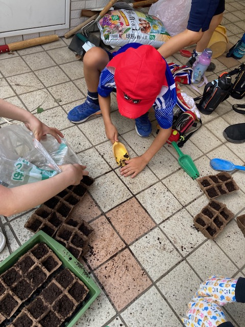 丁寧にスコップと手でこぼれた土を