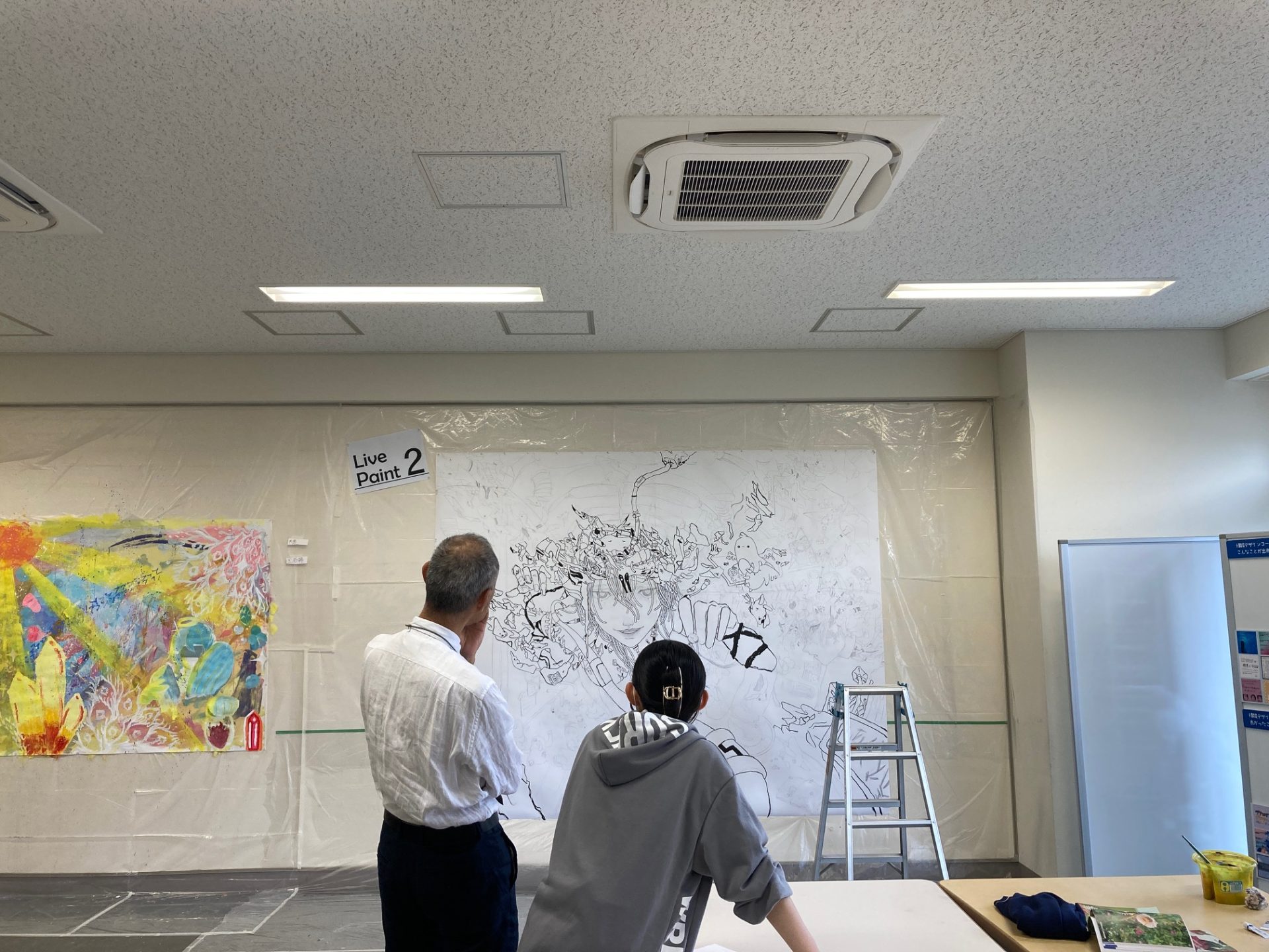 野川中美術部の先生と作品について語る本校生徒